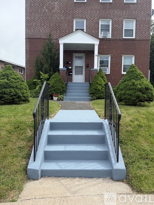 A brick building with a front porch and steps leading up to it.
