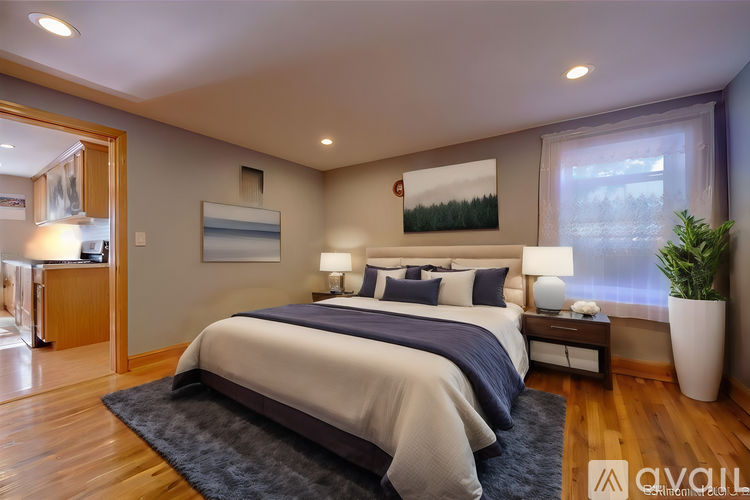 A bedroom with a large bed and a painting on the wall.