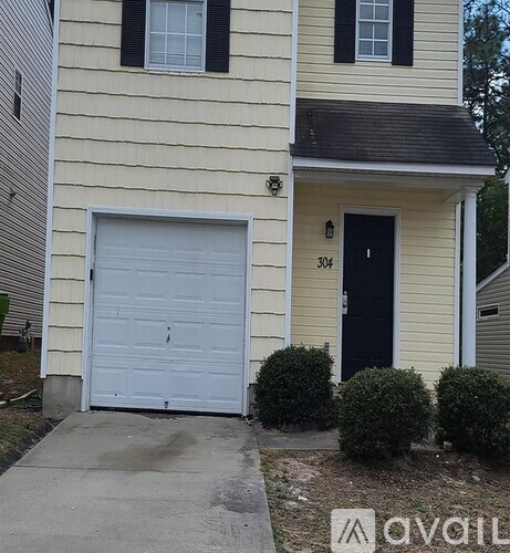 A house with a white garage door and black shutters.