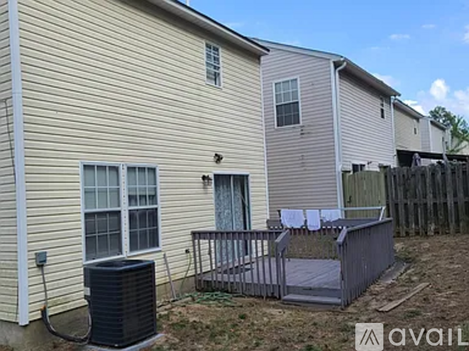 A house with a beige siding and a black air conditioning unit.