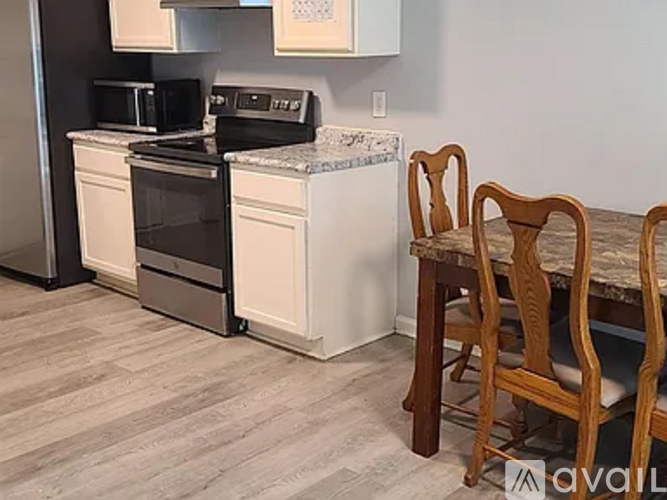 A kitchen with a white oven and black microwave.