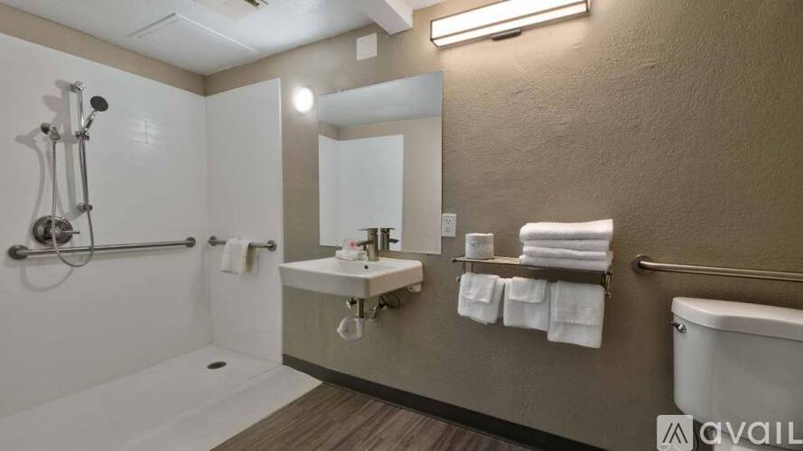 A bathroom with a white tub, sink, and towel rack.