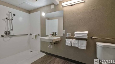 A bathroom with a white tub, sink, and towel rack.