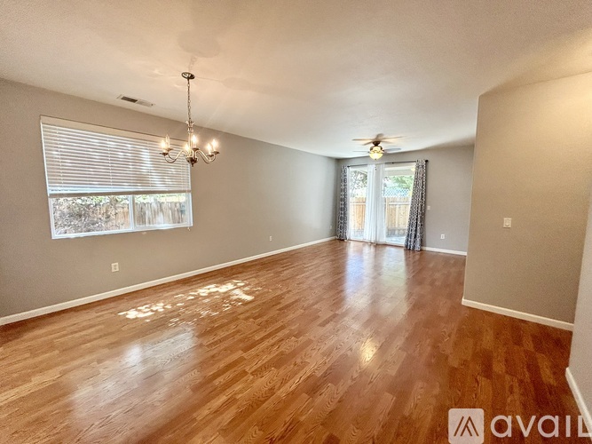 A room with wooden flooring and a ceiling fan.