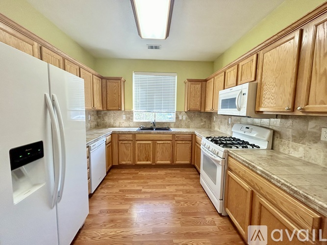 A kitchen with wooden cabinets and a white refrigerator.