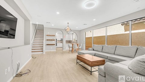 A spacious living room with a grey sofa and a wooden coffee table.