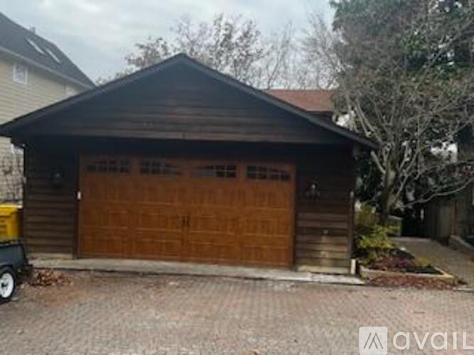 A wooden garage with a brown door is available for rent.