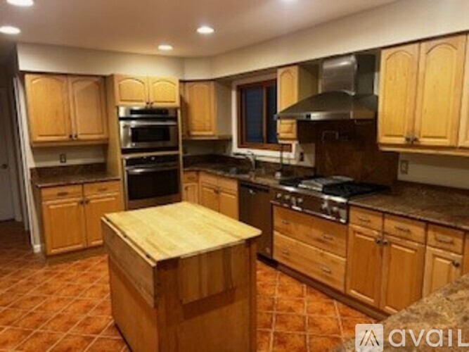 A kitchen with wooden cabinets and a tile floor.