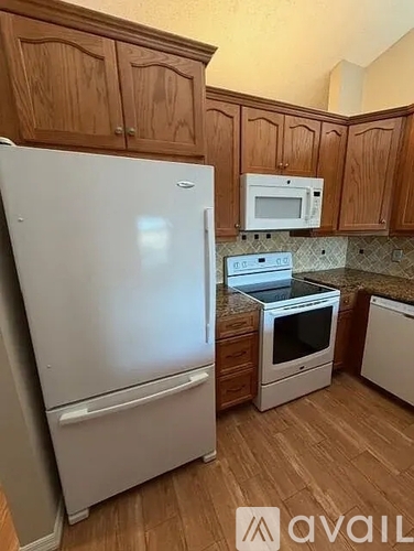 A kitchen with wooden cabinets and a white fridge.