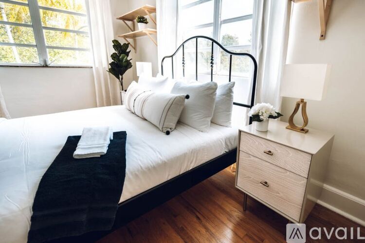 A bedroom with a white bed and a black metal headboard.