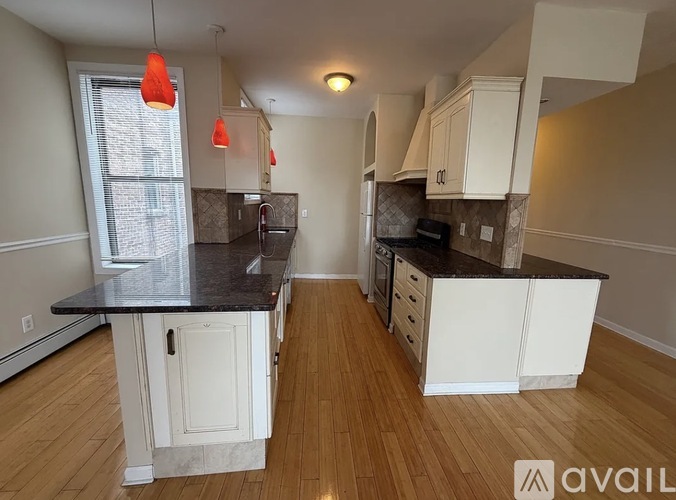 A kitchen with a black countertop and white cabinets.