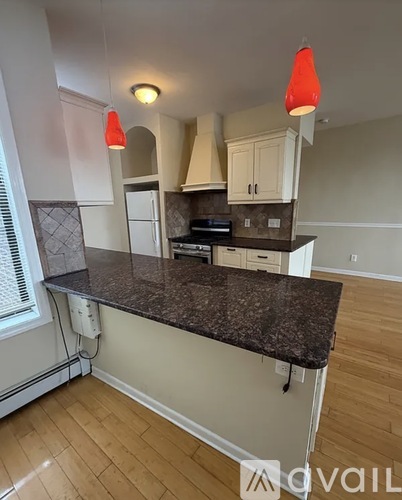 A kitchen with a granite countertop and white cabinets.