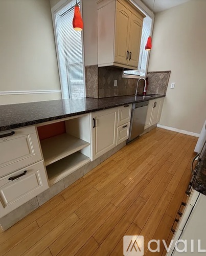 A kitchen with wooden floors and a black countertop.