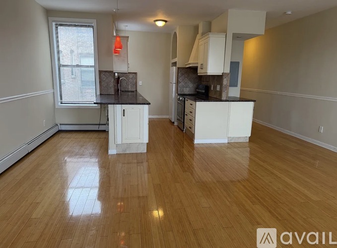 A kitchen with wooden floors and white cabinets is available for rent.