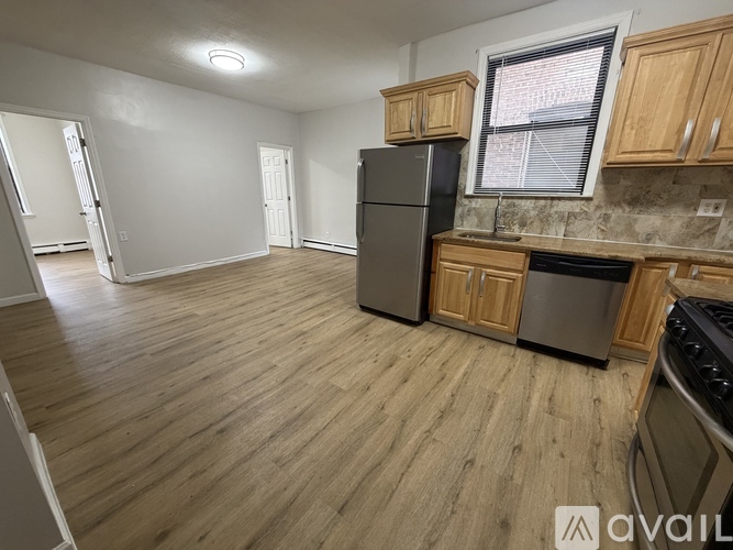 A kitchen with wooden floors and a black refrigerator.