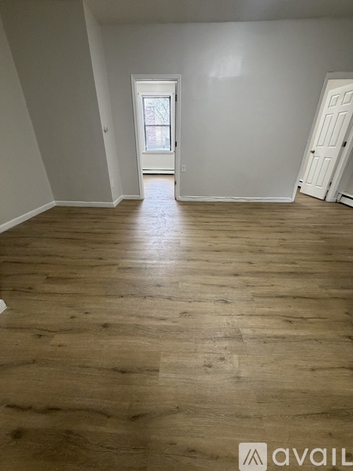 A room with wooden flooring and a white door.