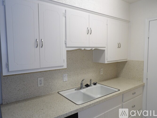 A kitchen with white cabinets and a granite countertop.