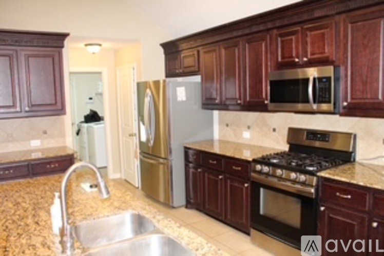 A kitchen with brown cabinets and a stainless steel refrigerator.