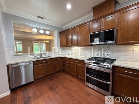 A kitchen with wooden cabinets and a stainless steel dishwasher.