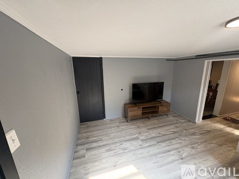 A living room with a television and a wooden cabinet.