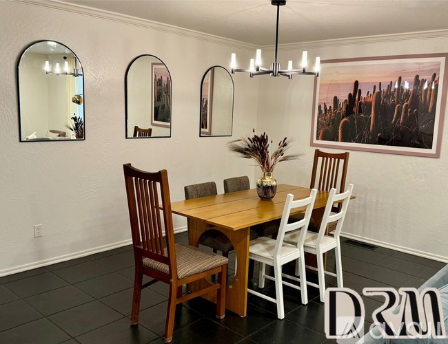 A dining room with a wooden table and chairs.