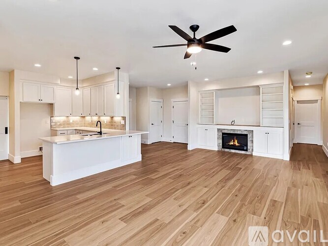 A spacious kitchen with a fireplace and wooden floors.