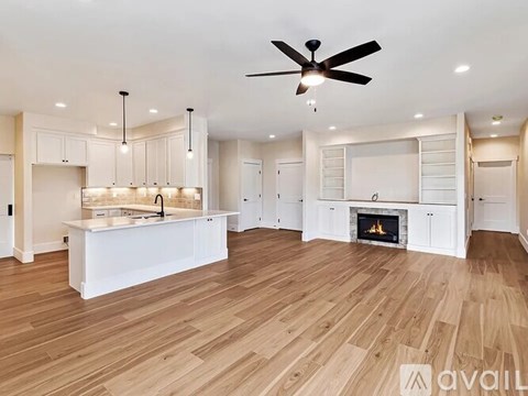 A spacious kitchen with a fireplace and wooden floors.