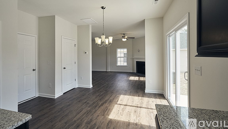 A spacious living room with a television and hardwood floors.