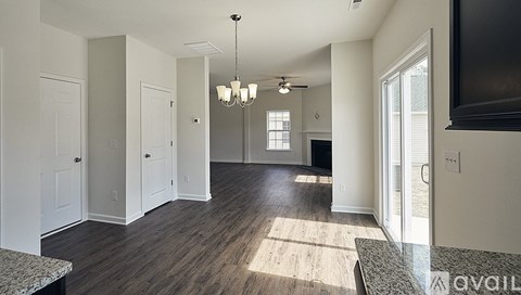 A spacious living room with a television and hardwood floors.