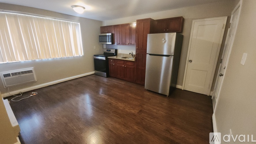 A kitchen with wooden floors and a refrigerator.