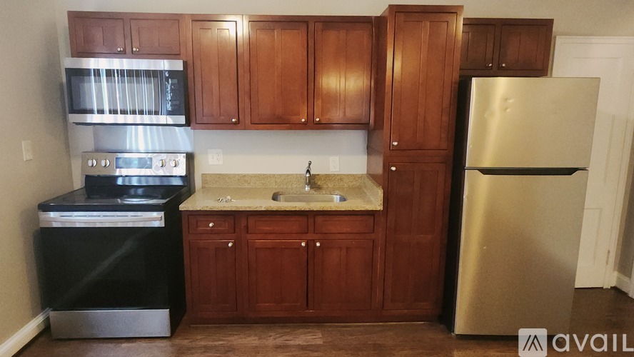 A kitchen with wooden cabinets and a stainless steel refrigerator.