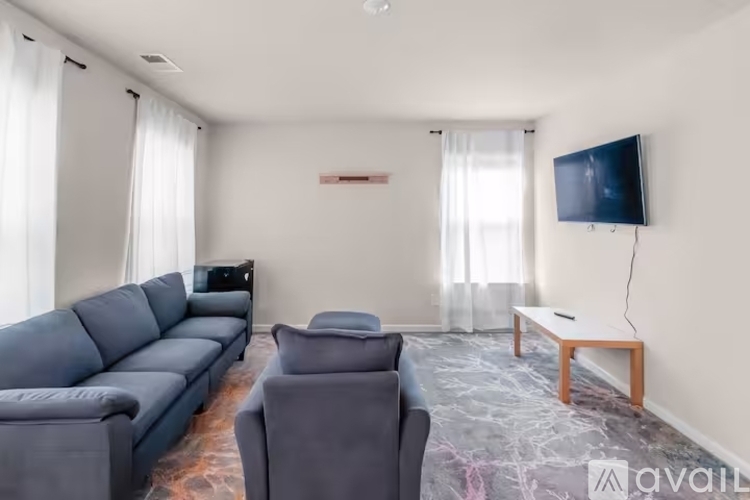 A living room with a grey sofa, a black television, and a wooden coffee table.