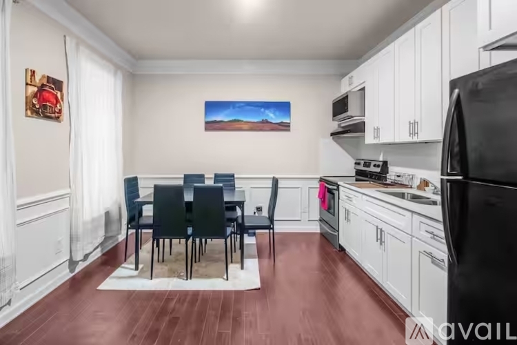 A kitchen with a dining table and chairs.