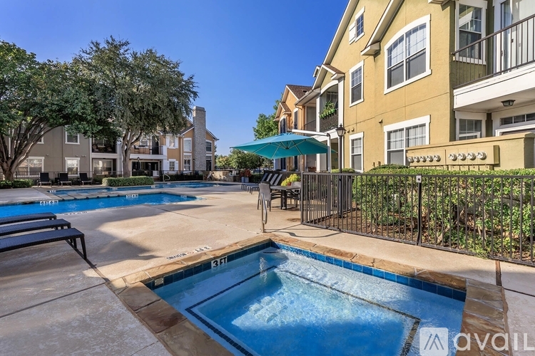 A swimming pool surrounded by a fence and a building in the background.