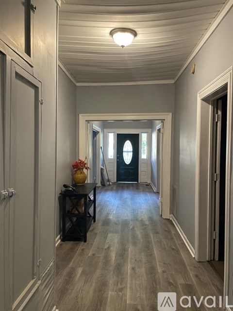 A hallway with a table and a vase of flowers.
