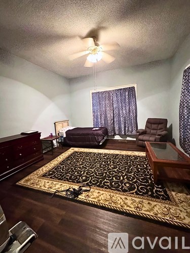 A room with a white door and a window with a black curtain.