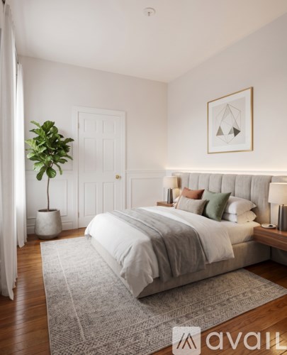 A bedroom with a large bed and a plant in a white pot.