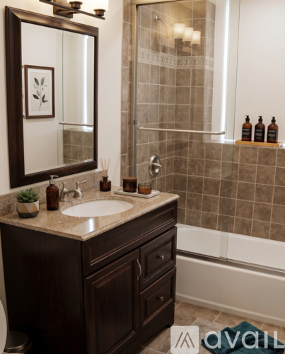 A bathroom with a brown vanity and a mirror above the sink.