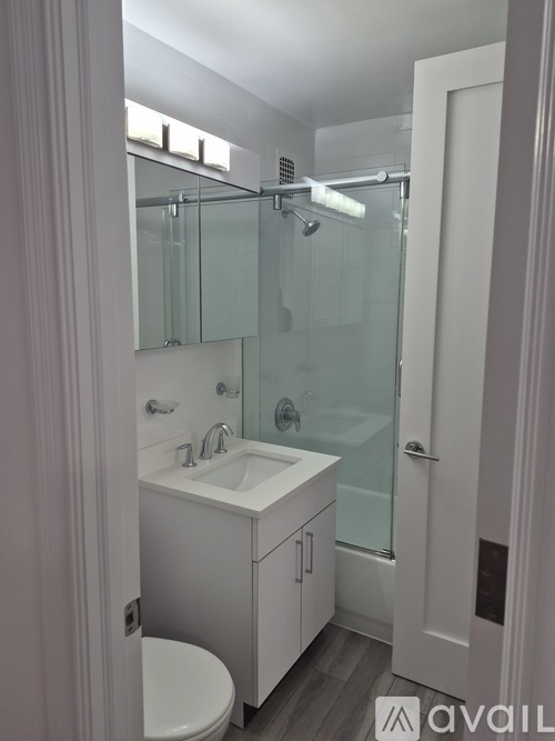 A bathroom with a white sink and a walk-in shower.