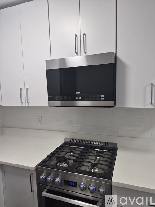 A modern kitchen with a stainless steel oven and microwave above it.