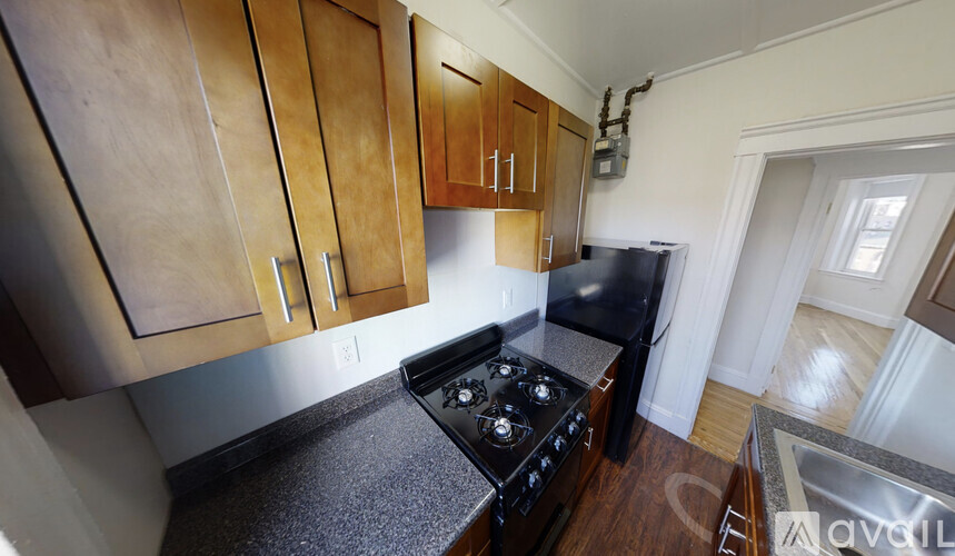 A kitchen with wooden cabinets and a black stove top oven.