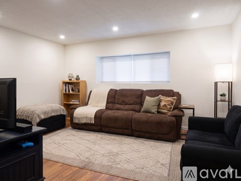 A living room with a brown couch and a television.