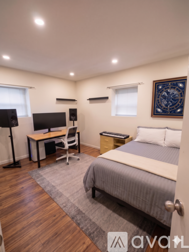 A bedroom with a bed, desk, and chair.