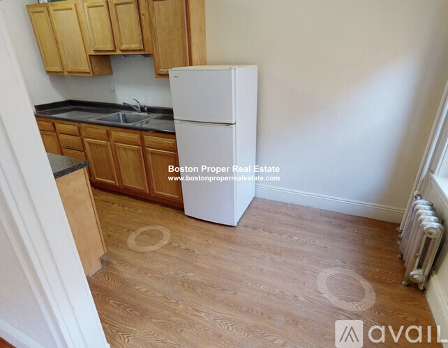 A kitchen with wooden cabinets and a white fridge.