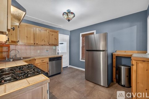 A kitchen with wooden cabinets and a stainless steel refrigerator.