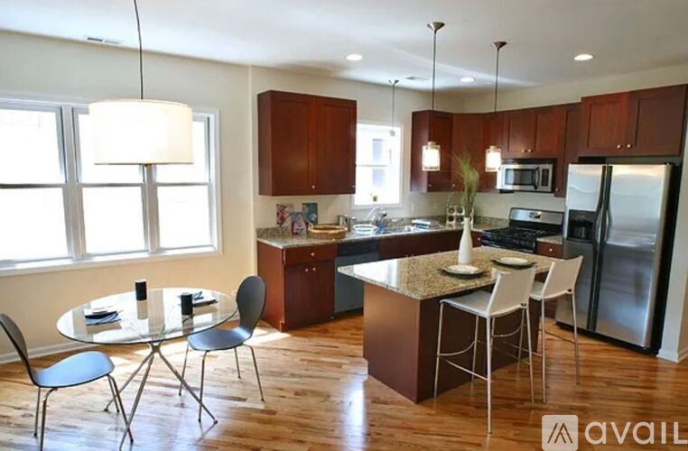 A kitchen with a table and chairs in front of it.
