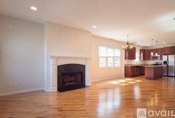 A spacious living room with a fireplace and wooden floors.