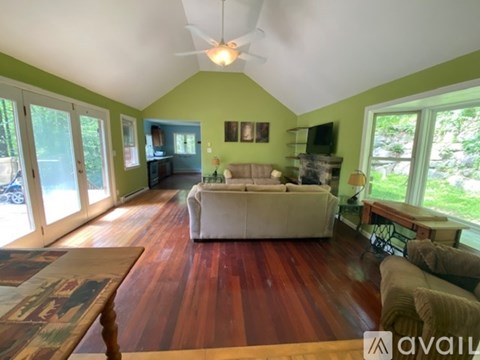 A living room with a white couch and a wooden floor.