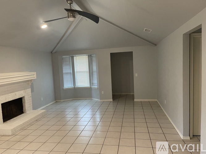 A room with a fireplace and a fan on the ceiling.
