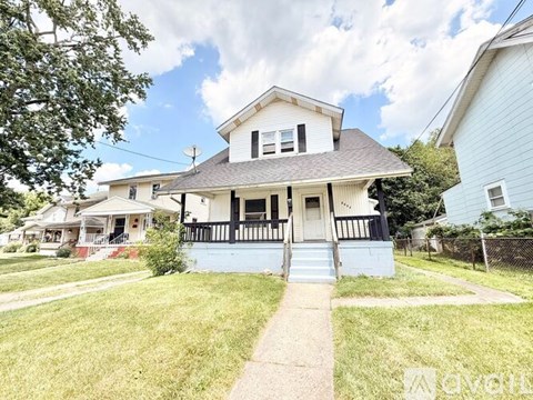 A two-story house with a front porch and a small front yard.